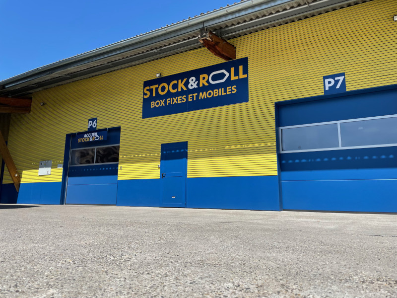 Photo d'un entrepôt de couleurs jaune et bleu et portant le logo de l'entreprise de stockage Stock&Roll